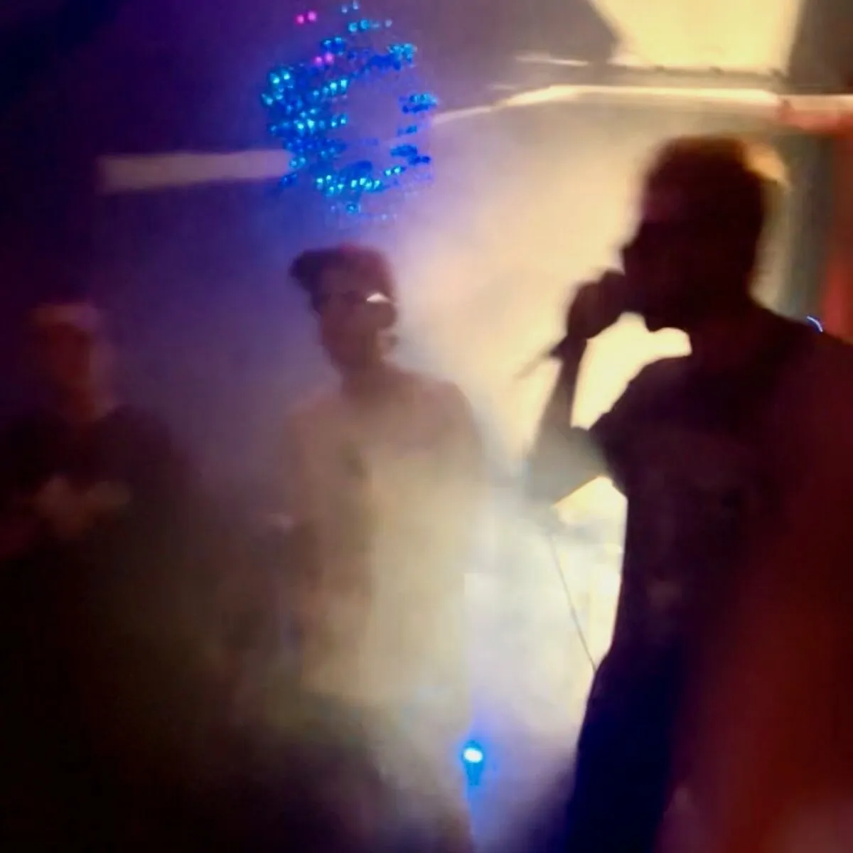 3 Ace Quincy — A Collection: three silhouetted performers in blue and amber haze